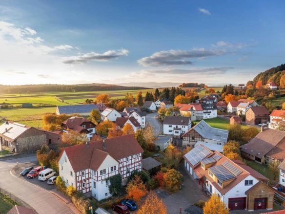 Aerial view of a modern countryside village with solar-roof homes during autumn — ideal example of property market trends shifting post-COVID for homeowners wanting to sell home quick